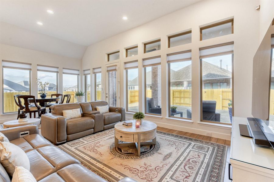 Sunroom / solarium featuring wood finished floors, recessed lighting, and vaulted ceiling