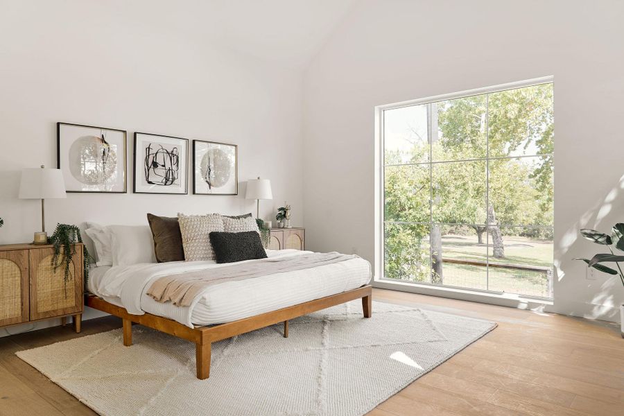 Bedroom featuring hardwood / wood-style flooring and vaulted ceiling Bedroom featuring hardwood / wood-style flooring and vaulted ceiling