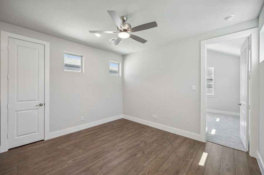 Unfurnished room featuring ceiling fan and dark hardwood / wood-style flooring