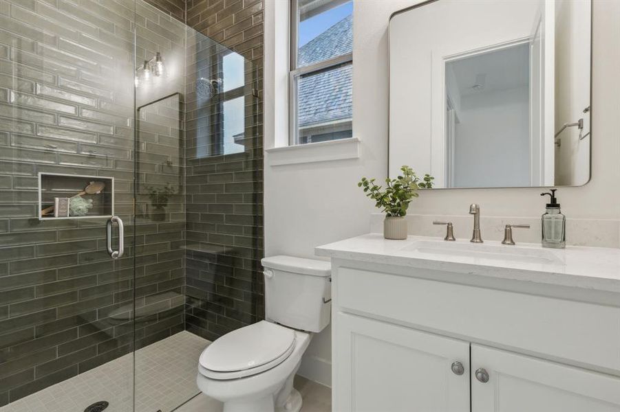 Bathroom featuring vanity, an enclosed shower, and toilet