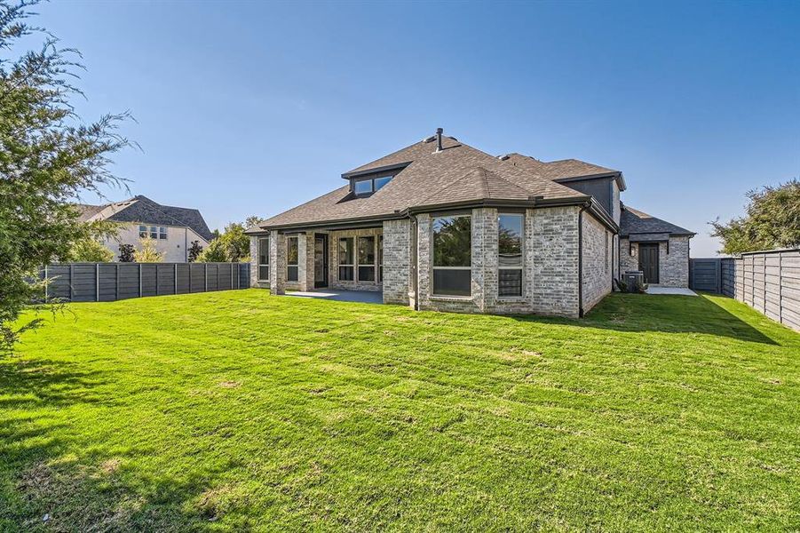 Back of house with a yard and a patio