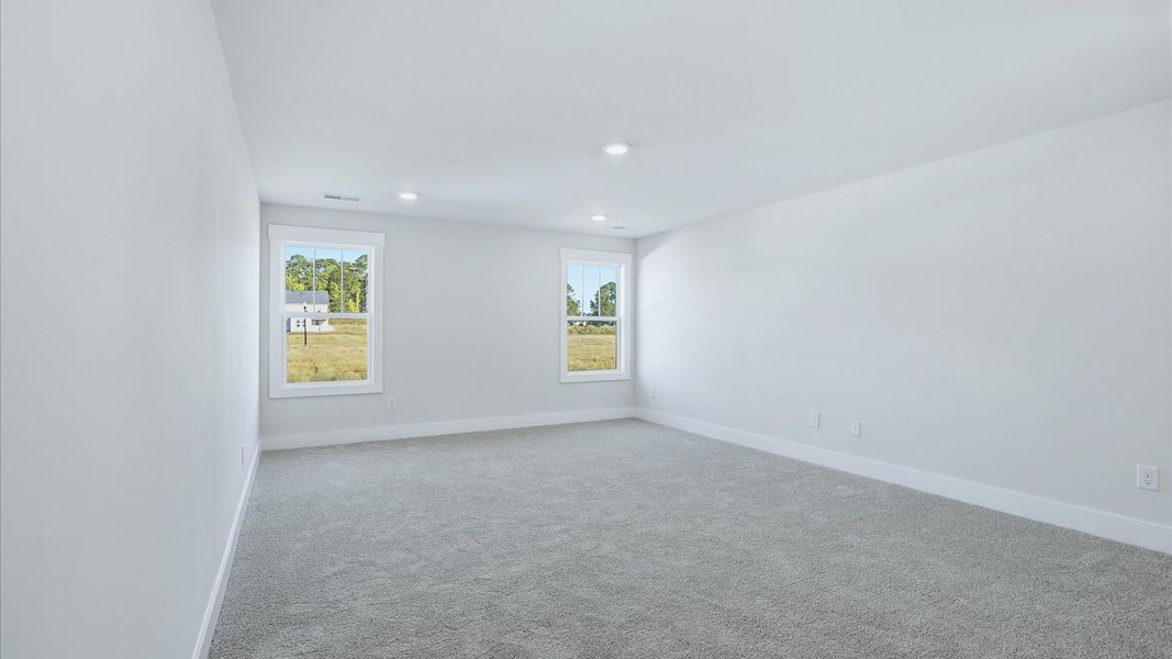 Inviting bonus room with cozy carpet, perfect for casual gatherings or quiet relaxation