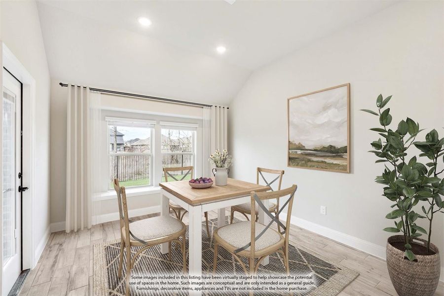 Bright dining area with wood table, four chairs, vaulted ceiling, and large window overlooking backyard