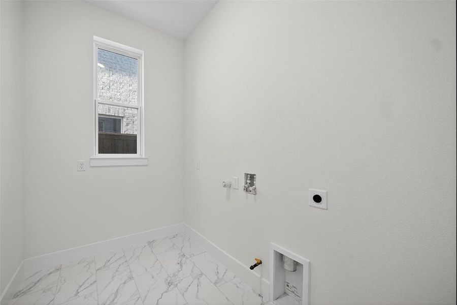 Washroom with gas dryer hookup, light marble finish flooring, hookup for a washing machine, and electric dryer hookup Washroom with gas dryer hookup, light marble finish flooring, hookup for a washing machine, and electric dryer hookup
