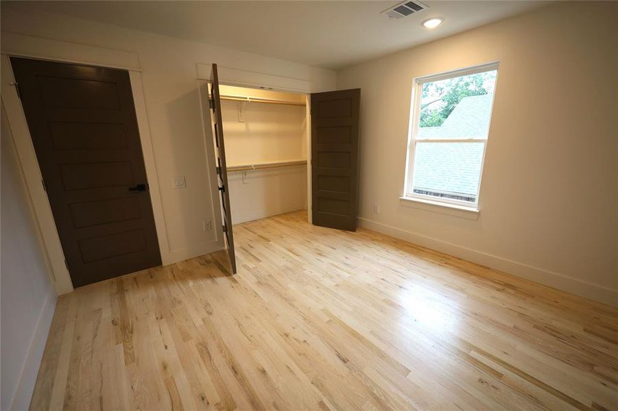 Unfurnished bedroom with light wood flooring, a closet, and recessed lighting