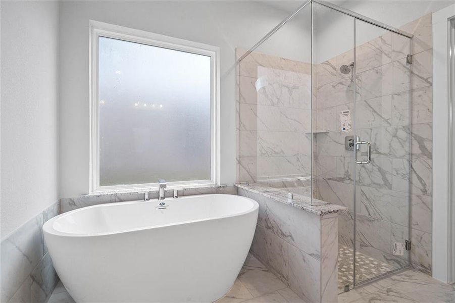 This additional view of the primary bath features a large walk-in shower with tile surround and a separate garden tub perfect for soaking after a long day.