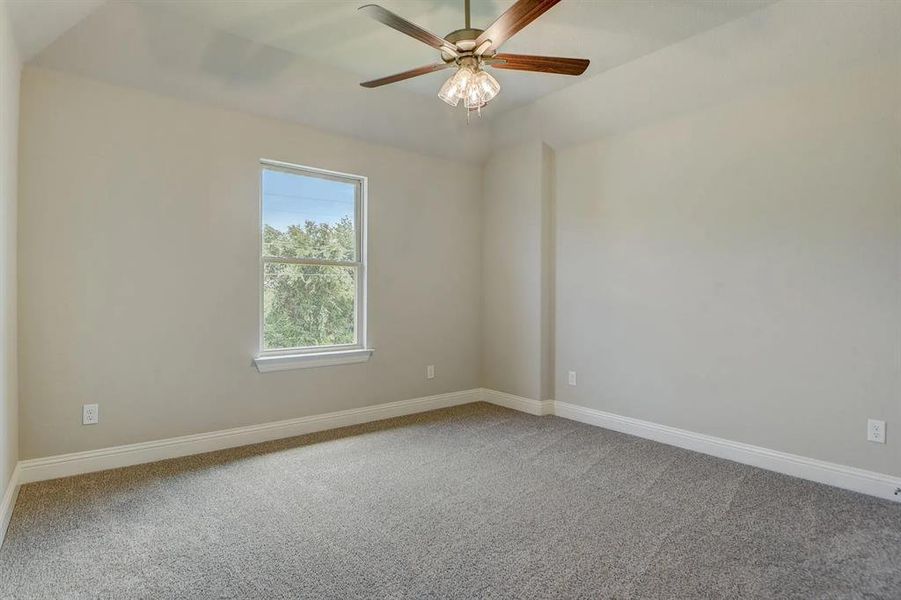 Empty room with carpet floors, ceiling fan, and baseboards