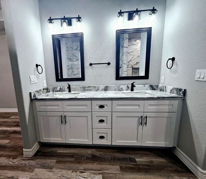Primary bathroom vanity with dual sinks.
