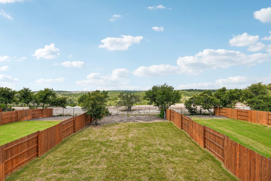 A spacious backyard with mature trees and verdant vistas, ideal for outdoor living.