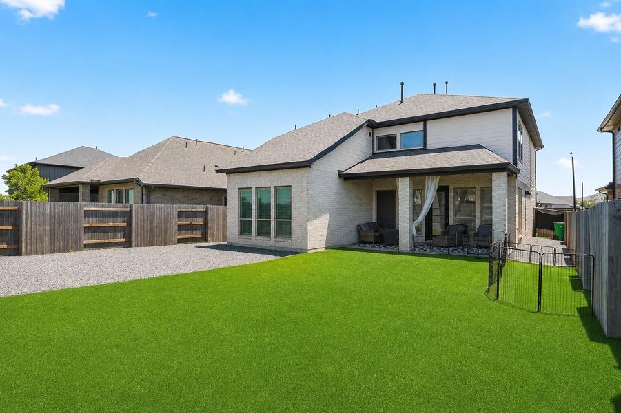 View of the backyard and covered patio highlighting the home's indoor-outdoor lifestyle.