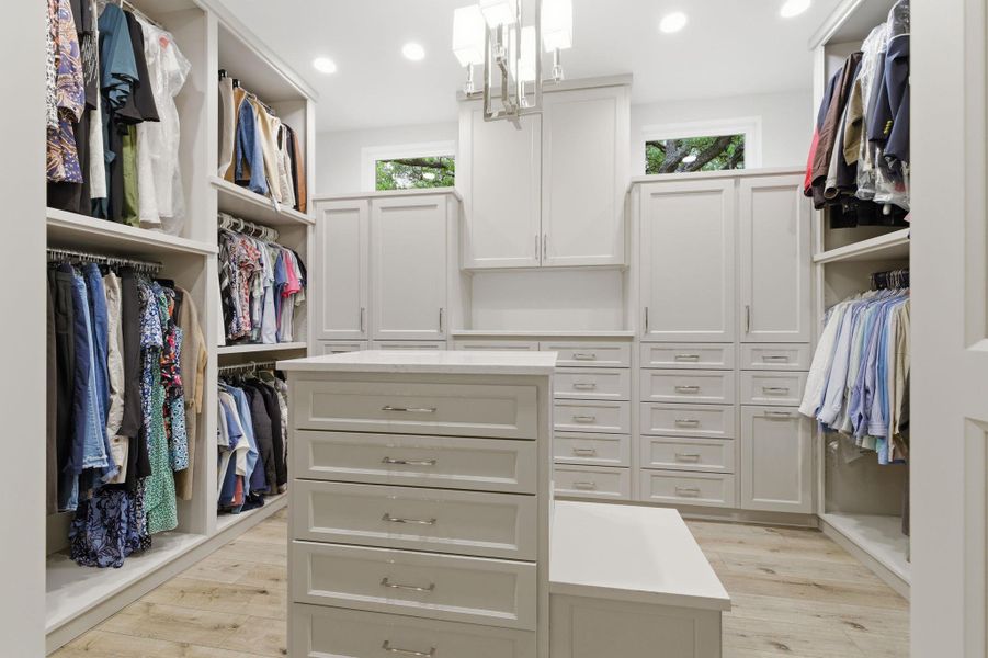 Walk in closet featuring light wood finished floors and hanging lights