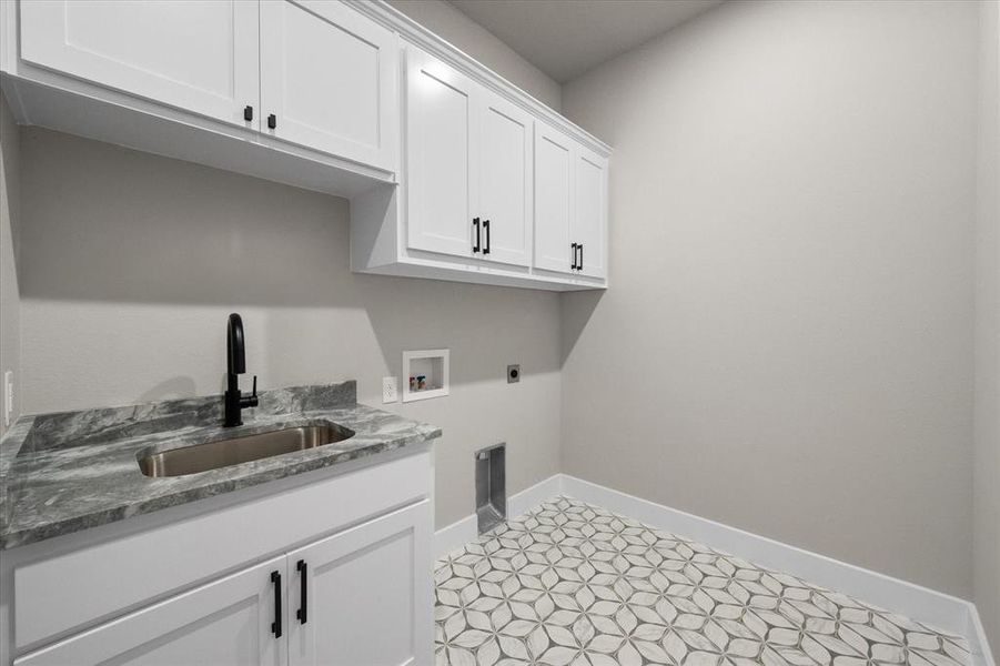 Utility room enjoys a sink, lots of cabinetry along with space for your washing machine & dryer