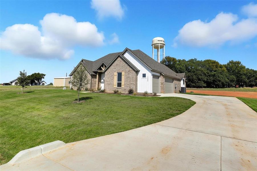 View of front of property featuring driveway, a front yard, brick siding, and an attached garage View of front of property featuring driveway, a front yard, brick siding, and an attached garage