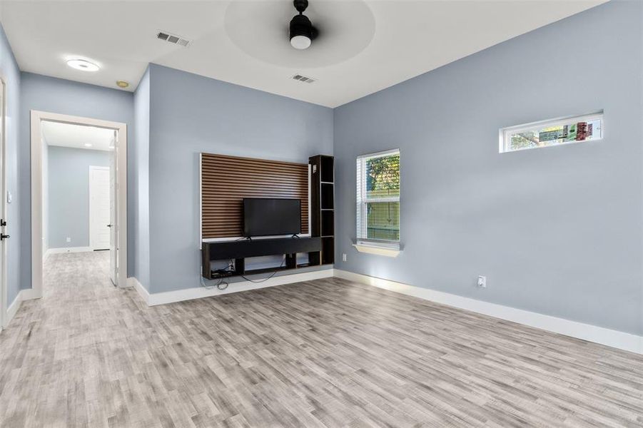 Unfurnished living room featuring ceiling fan and light wood-type flooring