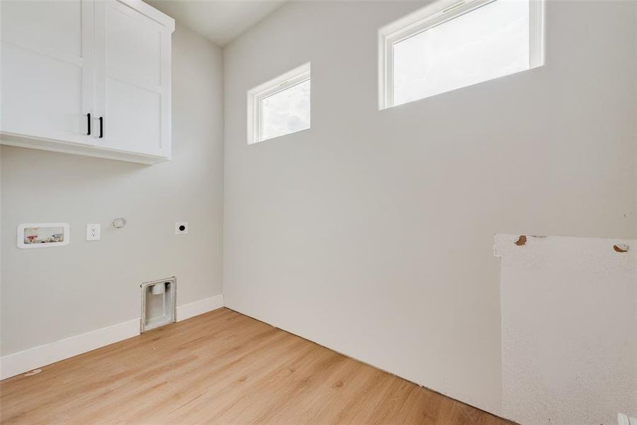 Washroom featuring light wood-type flooring, cabinets, hookup for a washing machine, hookup for an electric dryer, and gas dryer hookup