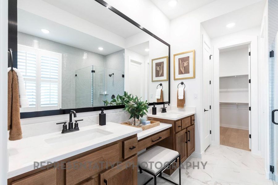 Bathroom with a stall shower, double vanity, marble look tile flooring, a walk in closet, and recessed lighting Bathroom with a stall shower, double vanity, marble look tile flooring, a walk in closet, and recessed lighting