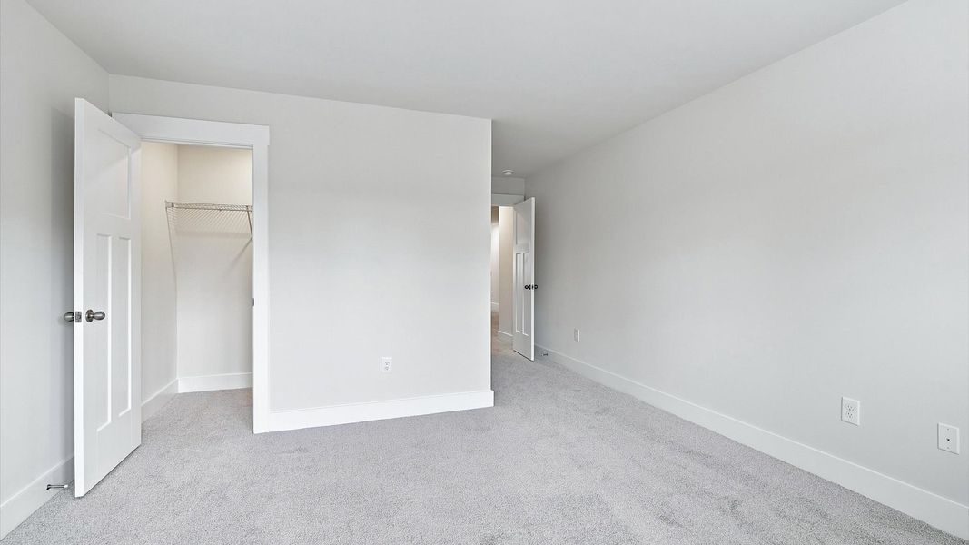 First-class secondary bedroom with comfortable carpeted flooring and generous closet space by DRB Homes