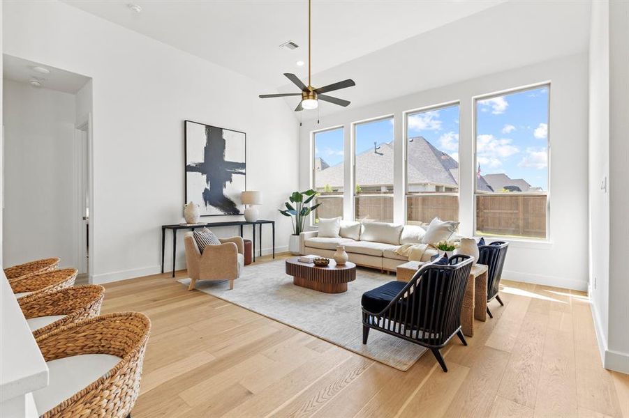 Living room featuring light wood finished floors, recessed lighting, and a ceiling fan