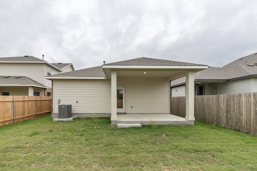 The property features a private yard with a covered patio area and a well-maintained lawn