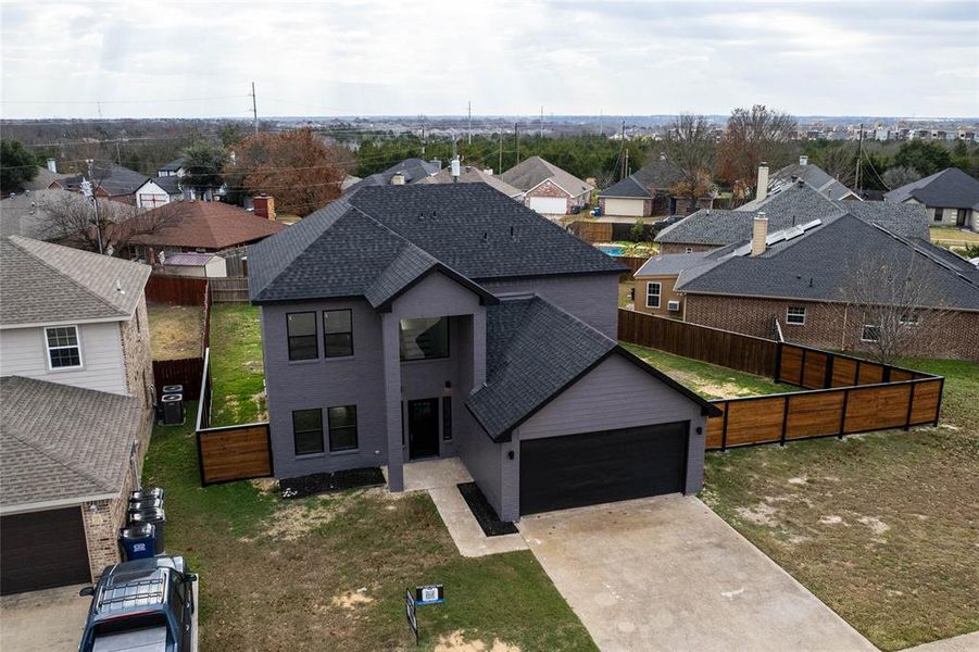 View of front of home featuring a garage, cooling unit, and a front lawn