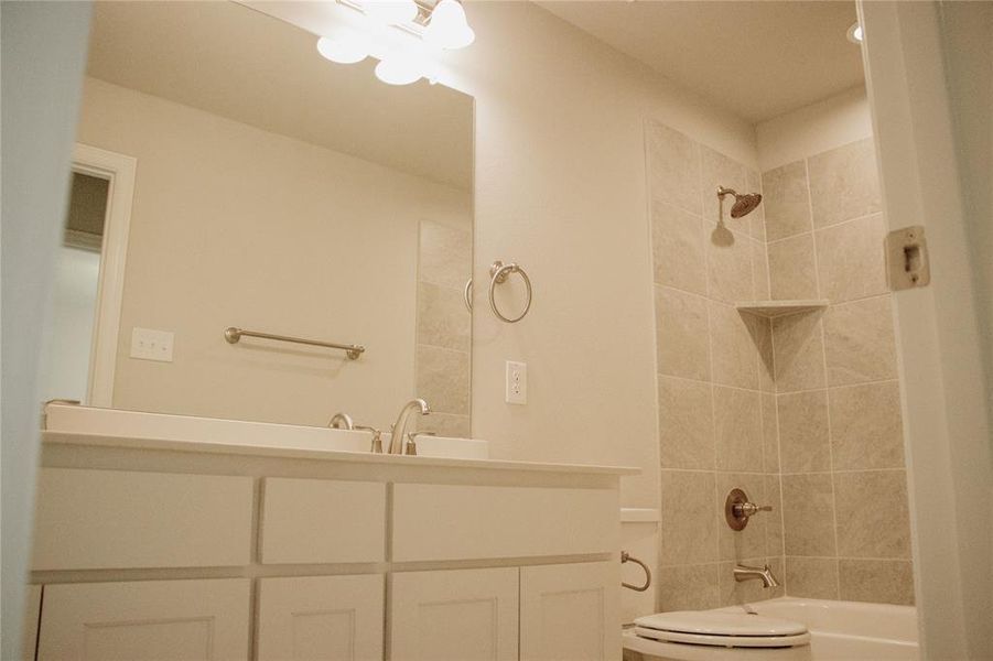 Bathroom featuring vanity and tiled shower / bath