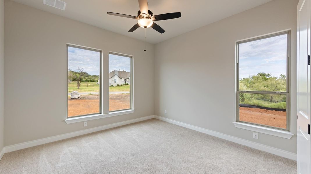 Unfurnished room featuring light carpet and a ceiling fan