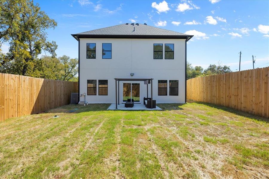 Rear view of property with a patio area, central AC unit, and a lawn