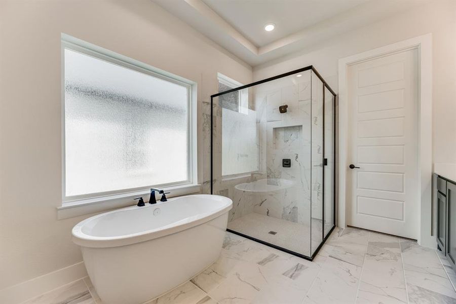 Bathroom with light marble finish floors, a marble finish shower, a freestanding bath, vanity, and recessed lighting Bathroom with light marble finish floors, a marble finish shower, a freestanding bath, vanity, and recessed lighting