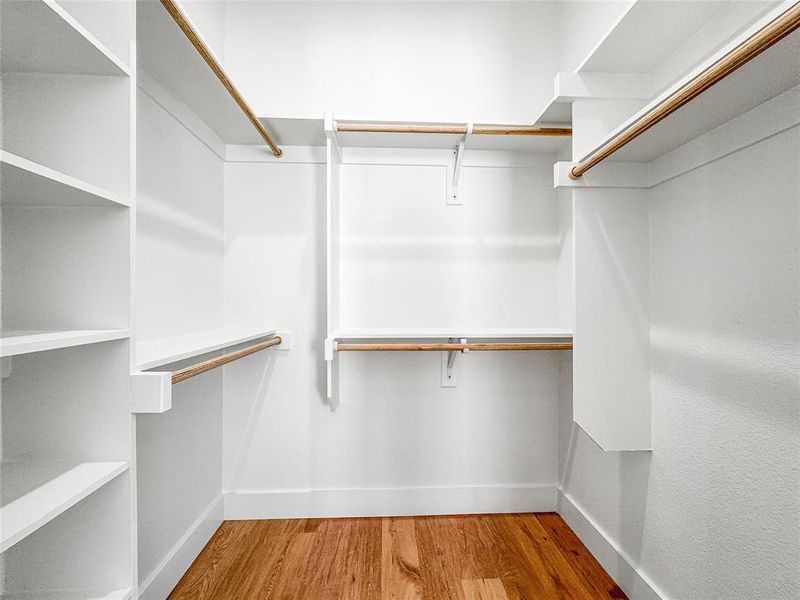 Walk in closet with wood finished floors