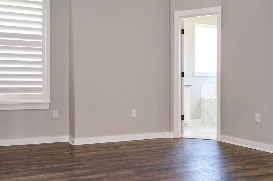 Unfurnished room with dark wood finished floors and baseboards Unfurnished room with dark wood finished floors and baseboards