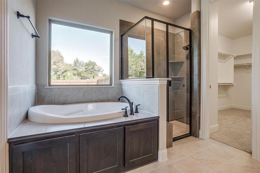 Bathroom featuring independent shower and bath and tile patterned floors