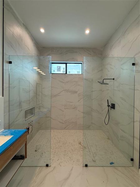 Full bath with a marble finish shower, vanity, tile walls, and recessed lighting Full bath with a marble finish shower, vanity, tile walls, and recessed lighting