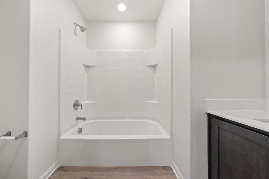 Bathroom with shower / bathing tub combination, hardwood / wood-style floors, and vanity