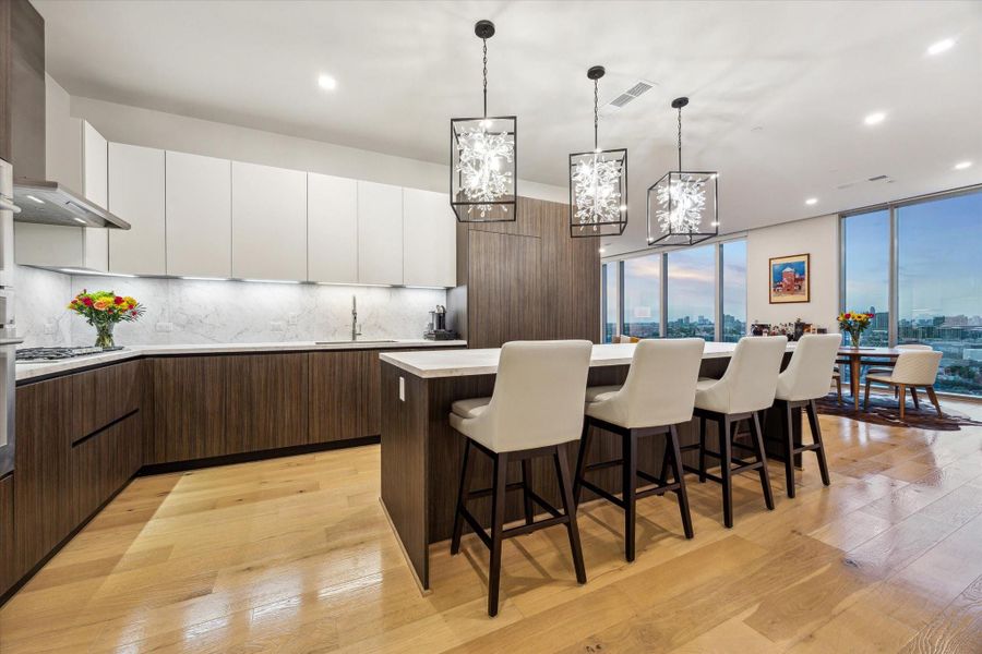 The gourmet kitchen is a true chef’s dream, featuring custom PEDINI cabinetry and premium Thermador appliances.