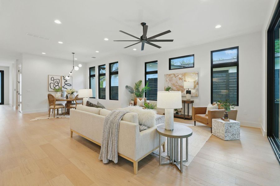 Living room with recessed lighting, light wood-type flooring, and a ceiling fan