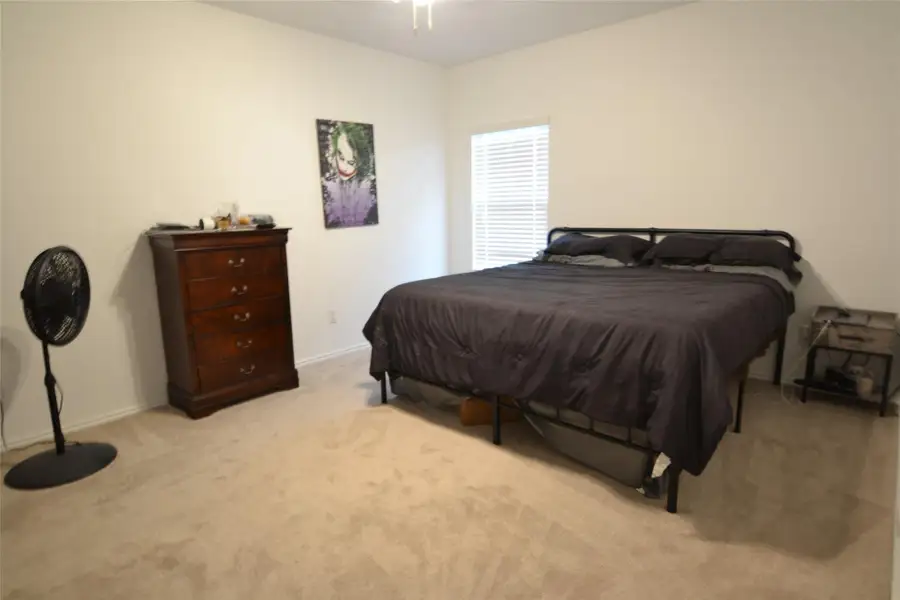 Bedroom featuring light carpet and baseboards