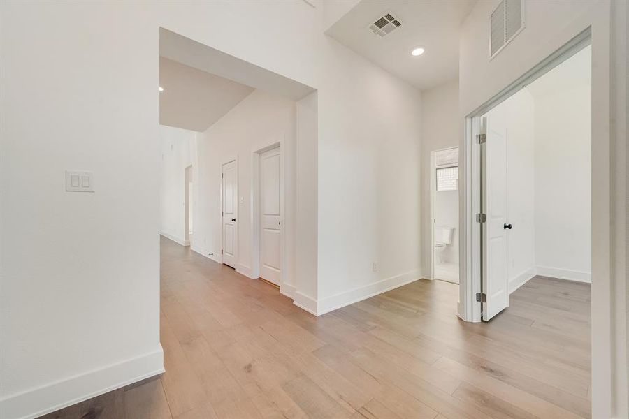 Hall with light wood-type flooring and recessed lighting Hall with light wood-type flooring and recessed lighting