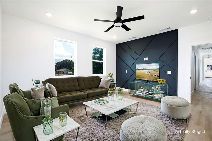 Living area with an accent wall, a ceiling fan, wood finished floors, a barn door, and recessed lighting