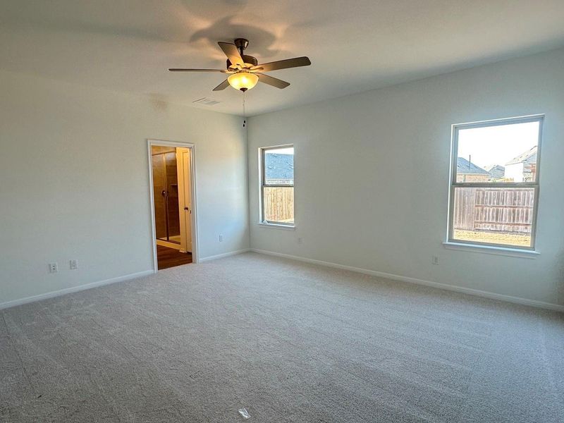 Carpeted spare room with baseboards and a ceiling fan Carpeted spare room with baseboards and a ceiling fan