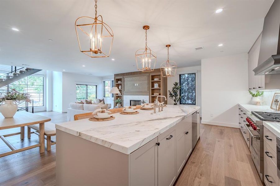 Kitchen with recessed lighting, light wood-type flooring, hanging light fixtures, stainless steel appliances, and a center island with sink Kitchen with recessed lighting, light wood-type flooring, hanging light fixtures, stainless steel appliances, and a center island with sink