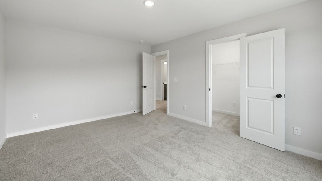 Spacious secondary bathroom with carpet and spacious closet