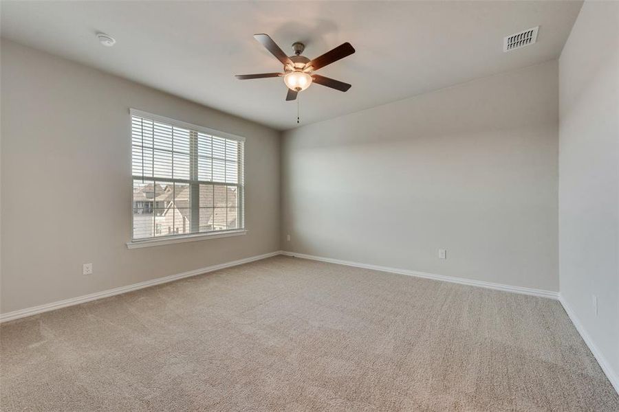 Empty room with light carpet and ceiling fan