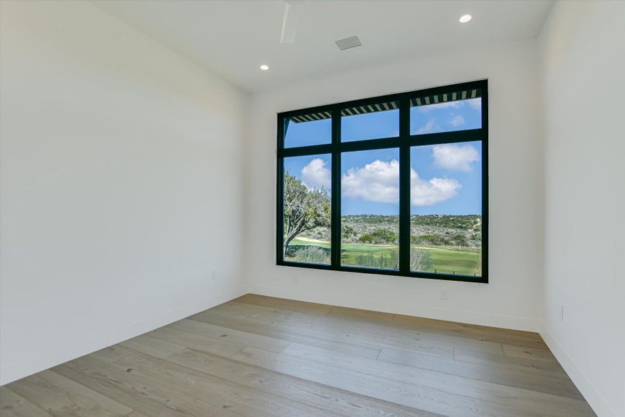 Empty room featuring light wood-style flooring and recessed lighting