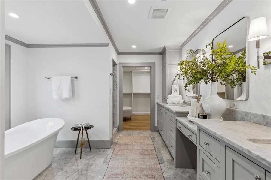 Full bathroom with visible vents, a freestanding bath, ornamental molding, vanity, and baseboards