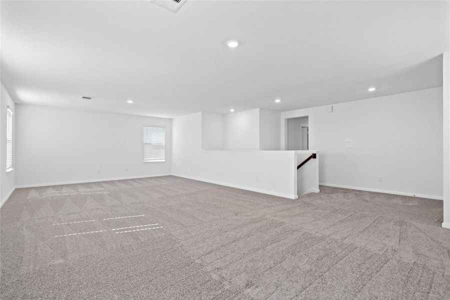 Another perspective of the Game Room, showcasing the staircase and hallway leading to the secondary bedrooms.
