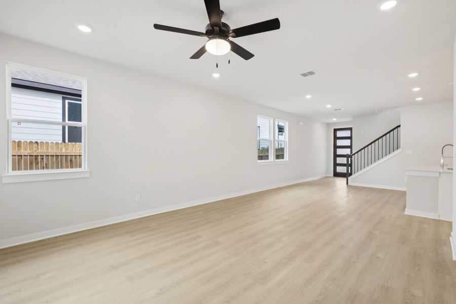 A room with a ceiling fan and a wood floor.