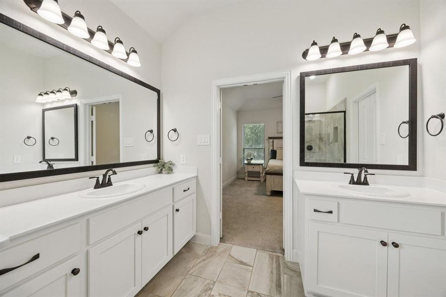 En-suite bathroom with marble like tiles, a separate shower, garden tub, separate vanities, and large walk-in closet.