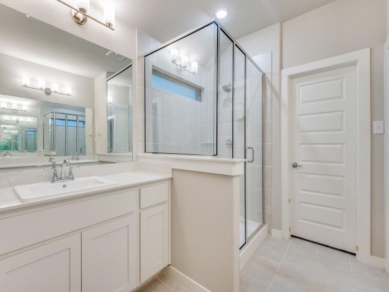 Bathroom featuring tile patterned floors, walk in shower, and vanity