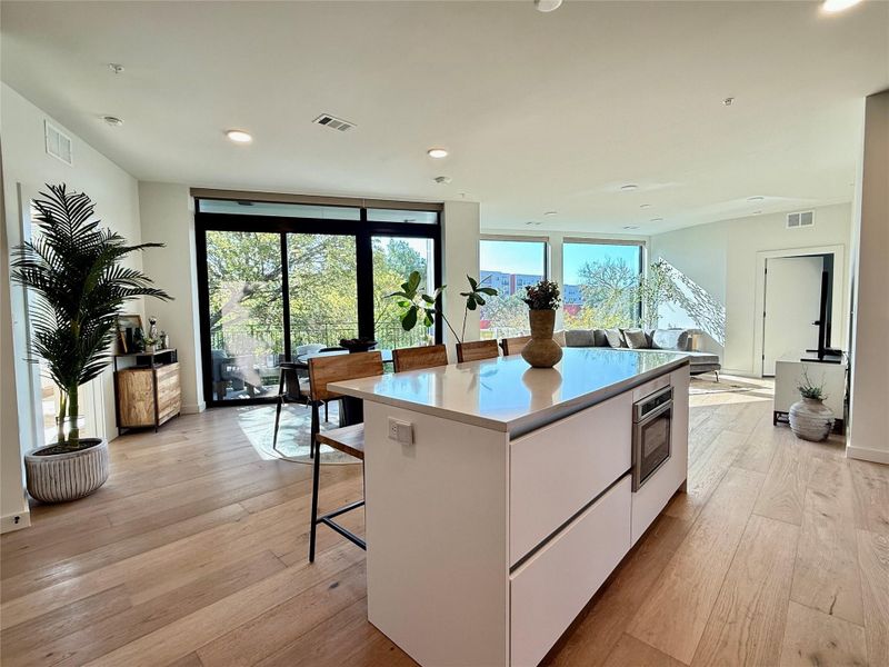 An open-concept living area features a spacious kitchen island and abundant natural light.