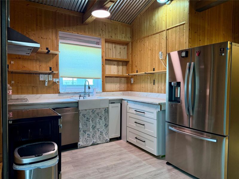 A well-appointed kitchen features rustic wood paneling and sleek stainless steel appliances.